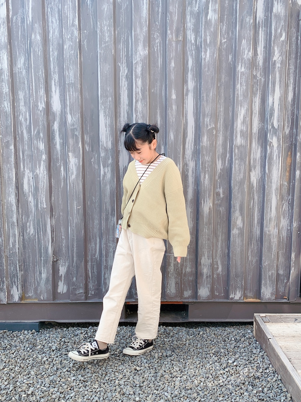 ブラック系のスニーカー、ベージュ系のデニムパンツ、グリーン系のカーディガン/ボレロを着用したキッズの冬コーディネートの1枚目の写真