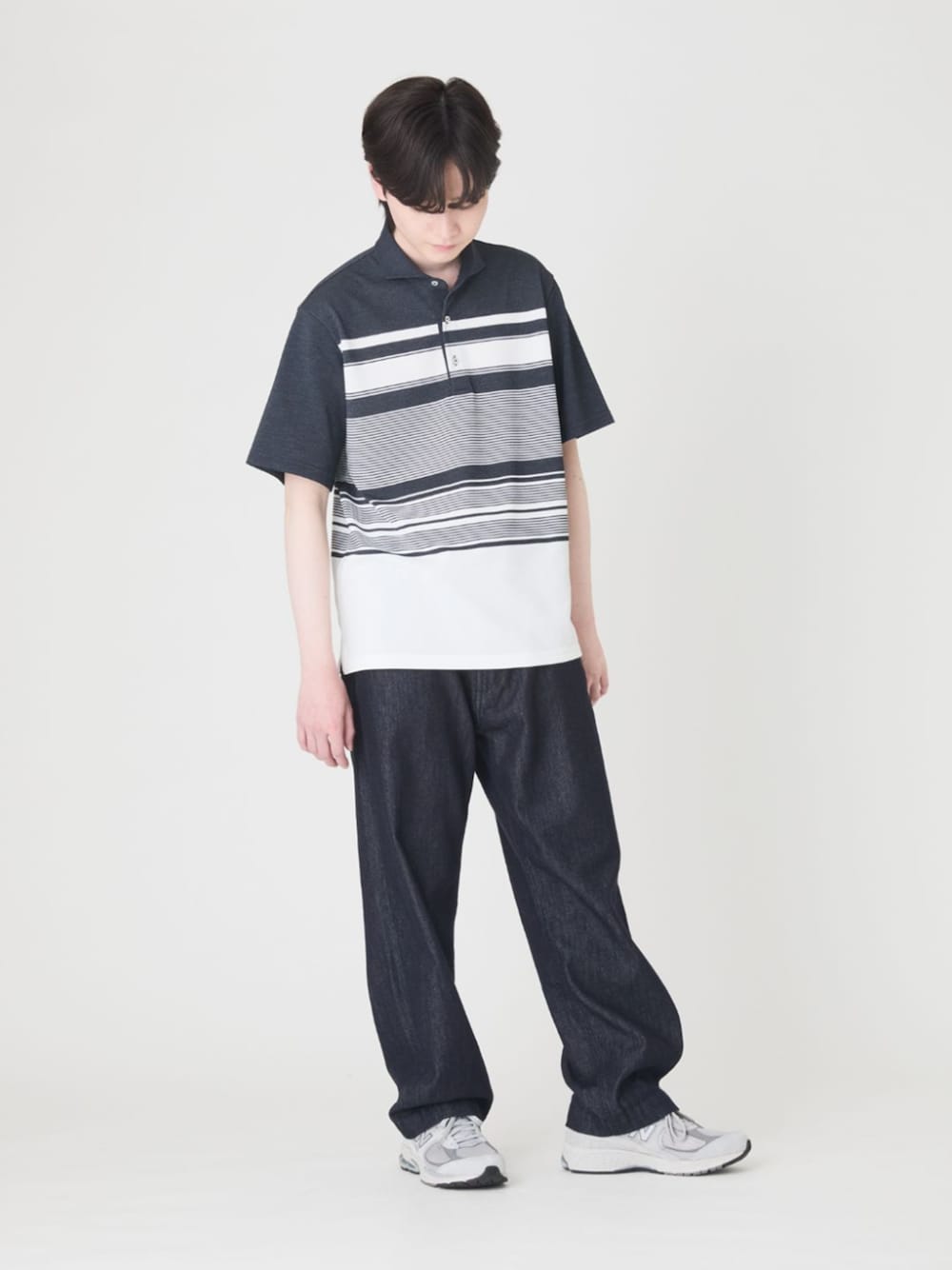ブルー系のデニムパンツ、ブルー系のポロシャツ、グレー系のスニーカーを着用したメンズの夏コーディネートの1枚目の写真