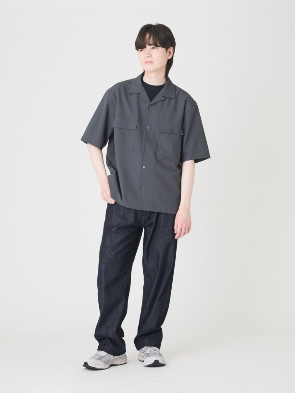 ブルー系のデニムパンツ、グレー系のTシャツ/カットソー、ブラック系のニット/セーターを着用したメンズの春コーディネートの1枚目の写真