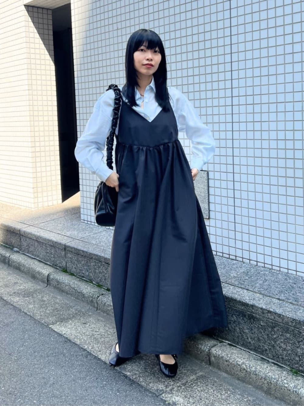 ブラック系のワンピース、ブルー系のシャツ/ブラウス、ブラック系のパンプスを着用したレディースの春コーディネートの1枚目の写真