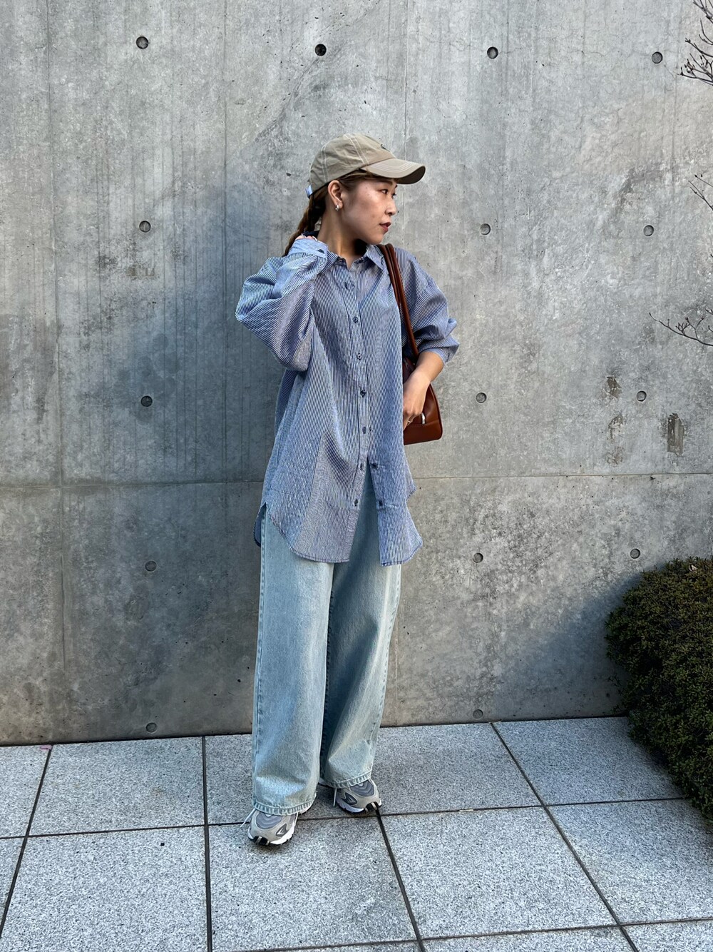 ブルー系のシャツ/ブラウス、ブルー系のデニムパンツ、イエロー系のボストンバッグを着用したレディースの春コーディネートの1枚目の写真