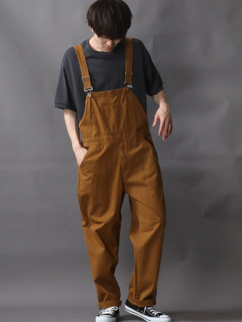 グレー系のTシャツ/カットソー、イエロー系のサロペット/オーバーオール、ブラック系のスニーカーを着用したメンズの夏コーディネートの1枚目の写真