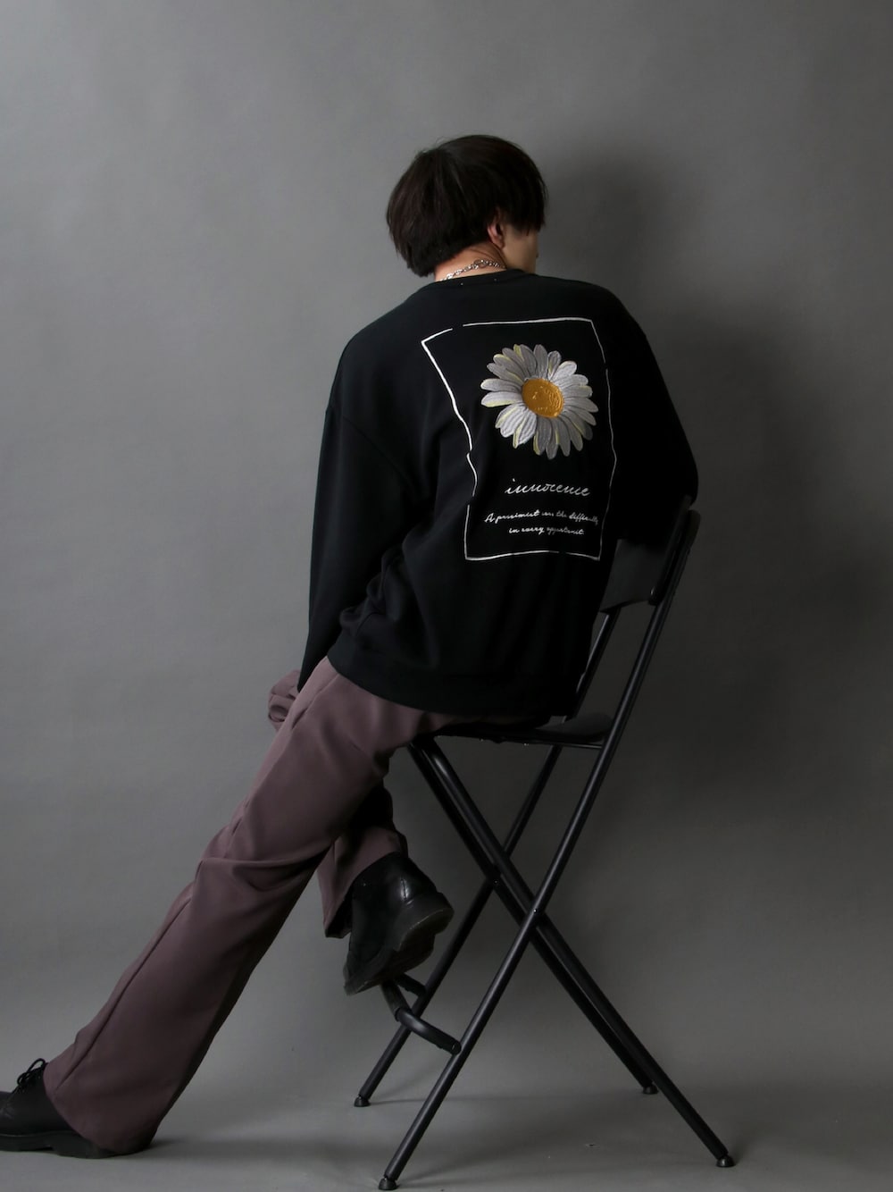 ブラック系のスウェット、ブラウン系のスラックス、ブラック系のドレスシューズを着用したメンズの冬コーディネートの1枚目の写真