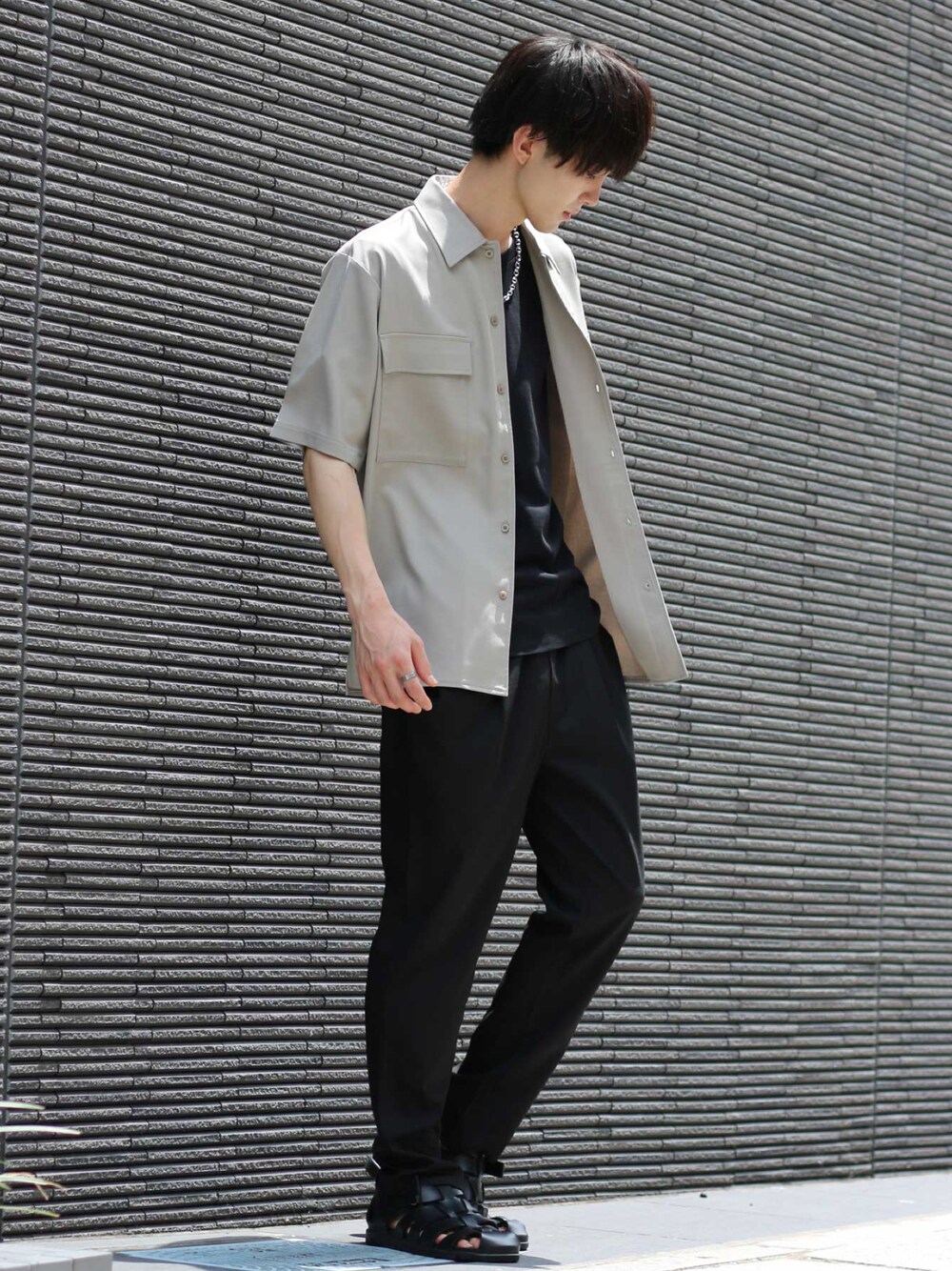 ベージュ系のセットアップ、ブラック系のTシャツ/カットソー、シルバー系のネックレスを着用したメンズの夏コーディネートの1枚目の写真
