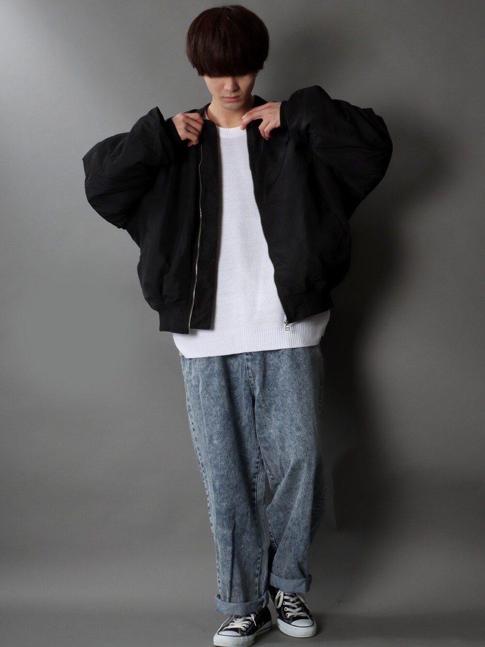 ブラック系のMA-1、ホワイト系のニット/セーター、ブルー系のデニムパンツを着用したメンズの冬コーディネートの1枚目の写真