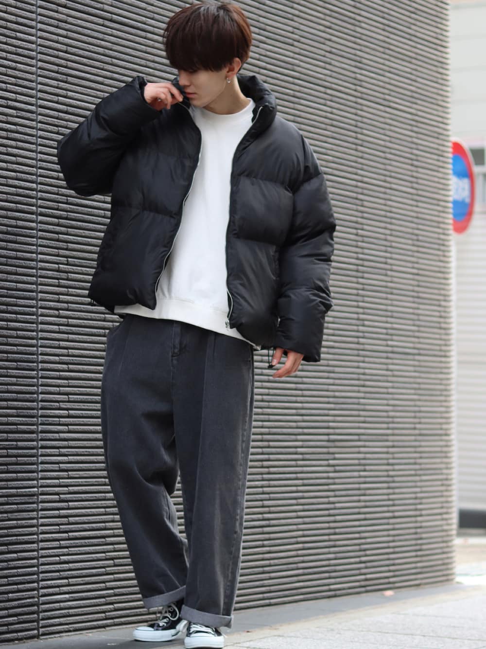 ブラック系のダウンジャケット/コート、ホワイト系のニット/セーター、ブラック系のデニムパンツを着用したメンズの冬コーディネートの1枚目の写真