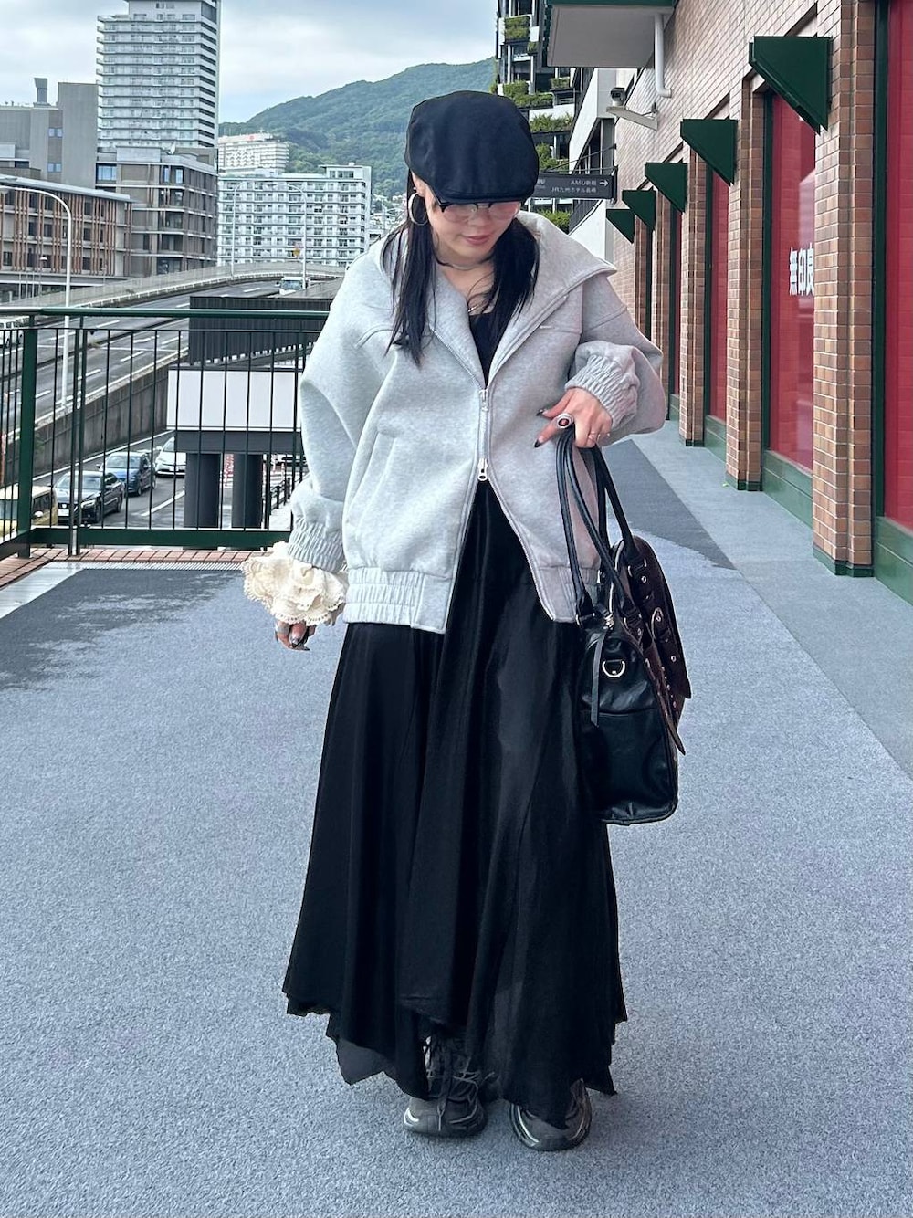 グレー系のパーカー、ブラック系のトートバッグ、ブラック系のキャミソールを着用したレディースの秋コーディネートの1枚目の写真