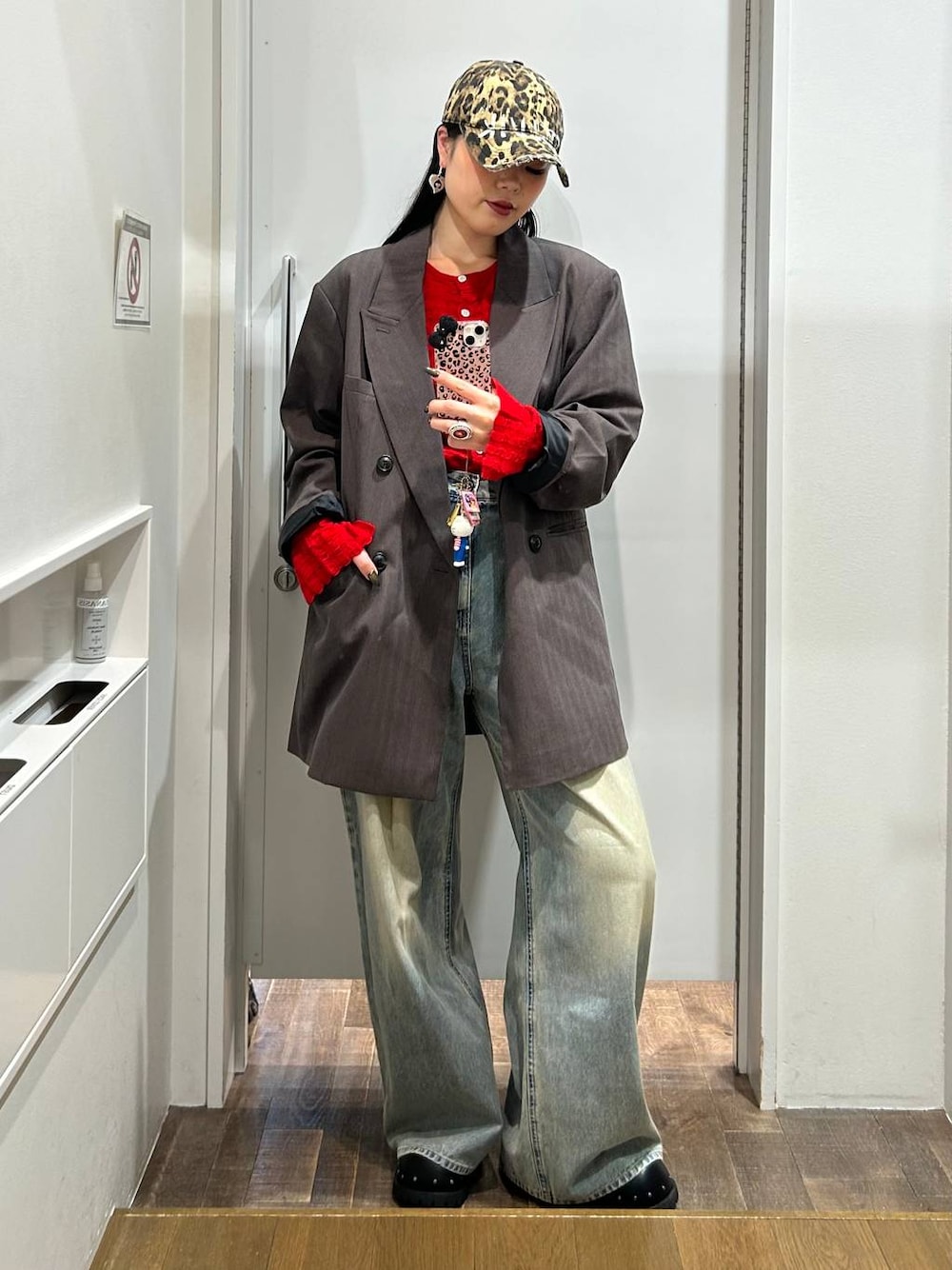 ブルー系のデニムパンツ、グレー系のテーラードジャケット、ブラック系のサンダルを着用したレディースの秋コーディネートの1枚目の写真