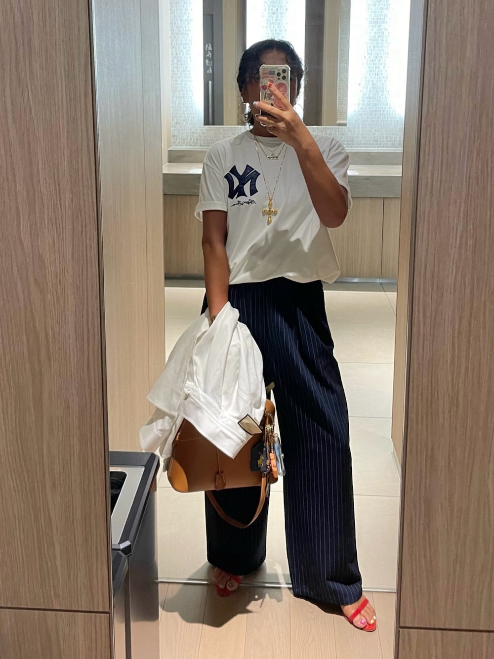 ホワイト系のTシャツ/カットソー、ブルー系のスラックス、レッド系のサンダルを着用したレディースの夏コーディネートの1枚目の写真