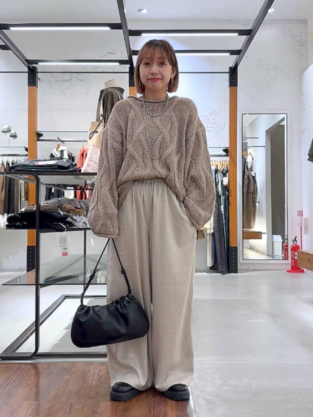 ホワイト系のその他パンツ、ブラック系のショルダーバッグ、シルバー系のネックレスを着用したレディースの秋コーディネートの1枚目の写真