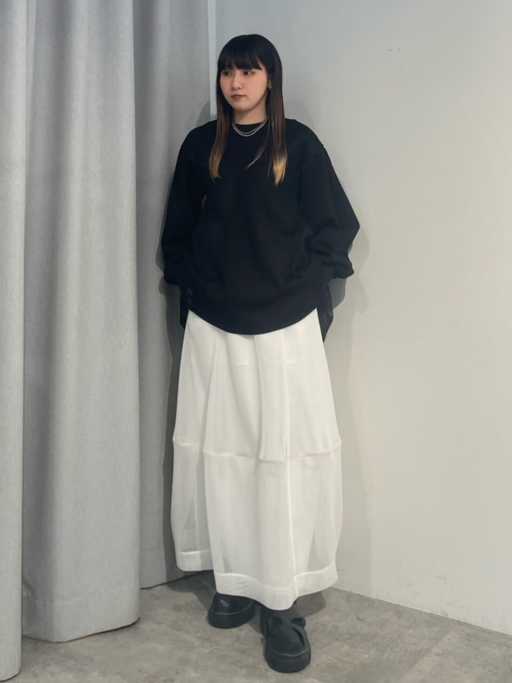 ブラック系のTシャツ/カットソー、ホワイト系のスカート、ブラック系のサンダルを着用したレディースの冬コーディネートの1枚目の写真