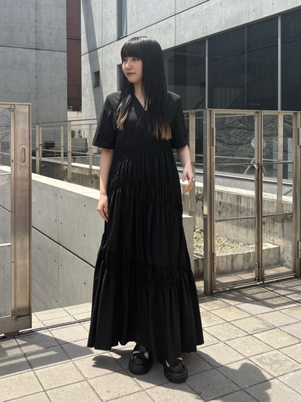 ブラック系のサンダル、ブラック系のワンピースを着用したレディースの夏コーディネートの1枚目の写真