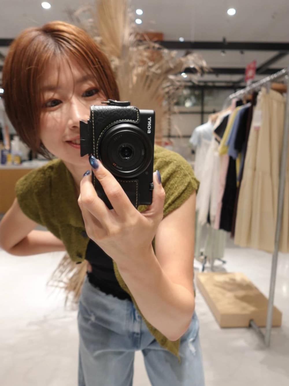 ブラック系のキャミソール、グリーン系のベスト、ブルー系のデニムパンツを着用したレディースの夏コーディネートの1枚目の写真