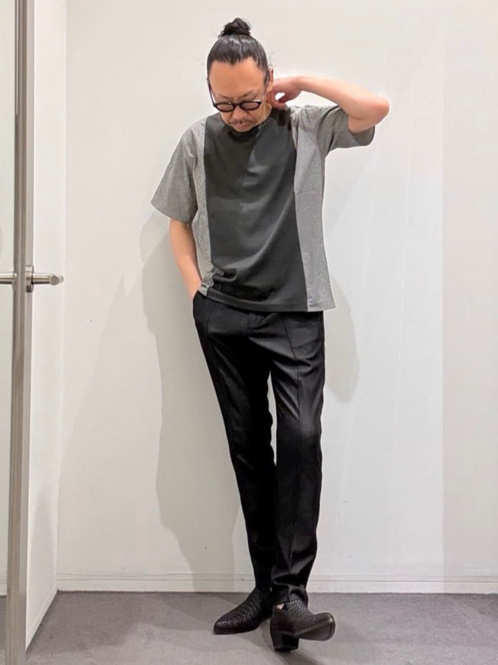 グレー系のTシャツ/カットソー、ブラック系のスリッポン、ブラック系のスラックスを着用したメンズの夏コーディネートの1枚目の写真