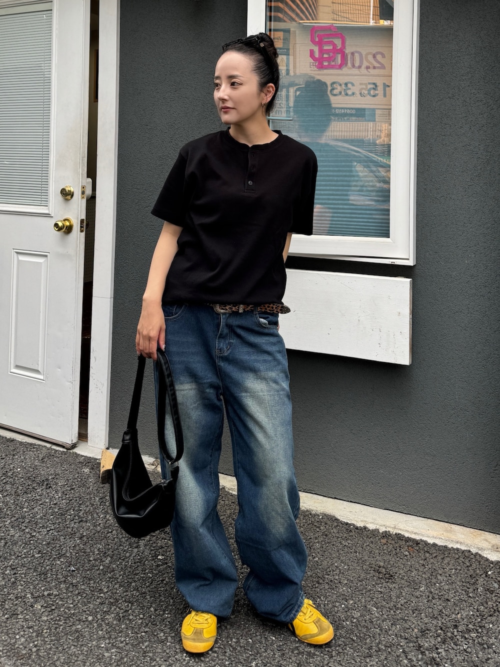 ブラック系のTシャツ/カットソー、ブルー系のデニムパンツ、ブラック系のショルダーバッグを着用したレディースの夏コーディネートの1枚目の写真