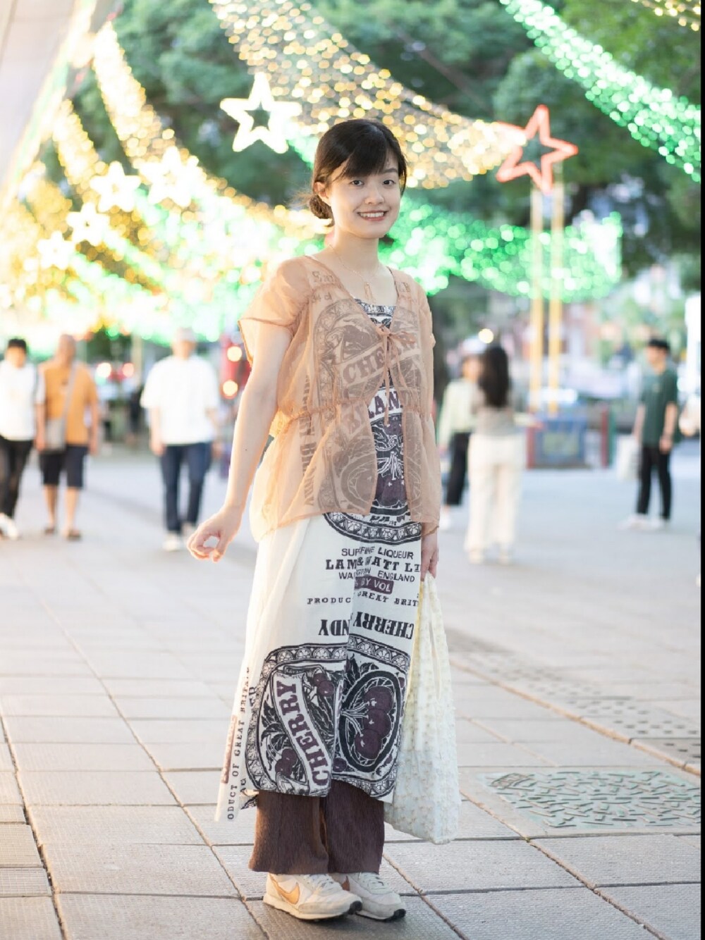 ベージュ系のジャンパースカート、ブラウン系のチノパンツを着用したレディースの春コーディネートの1枚目の写真