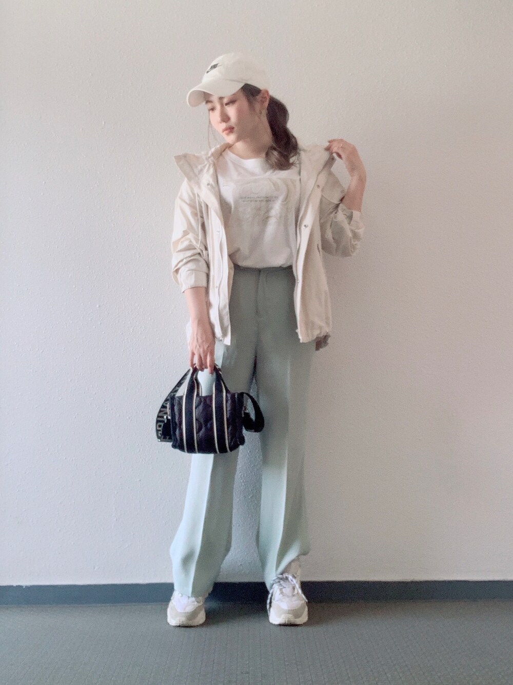 ホワイト系のTシャツ/カットソー、ホワイト系のマウンテンパーカー、ブラック系のバッグを着用したレディースの春コーディネートの1枚目の写真