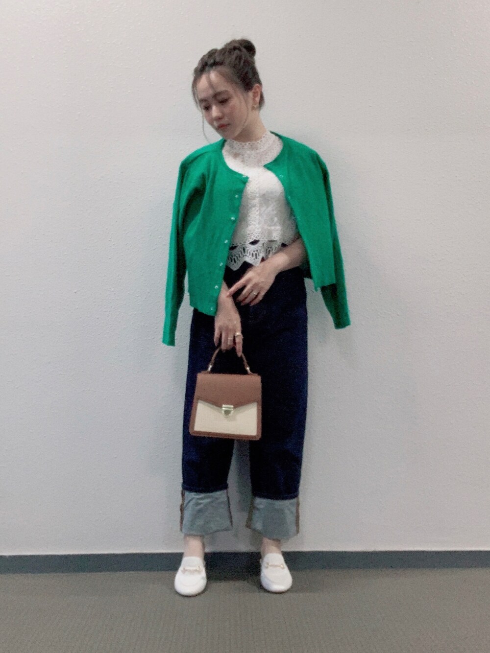 グリーン系のカーディガン/ボレロ、ブルー系のデニムパンツ、ブラウン系のバッグを着用したレディースの春コーディネートの1枚目の写真