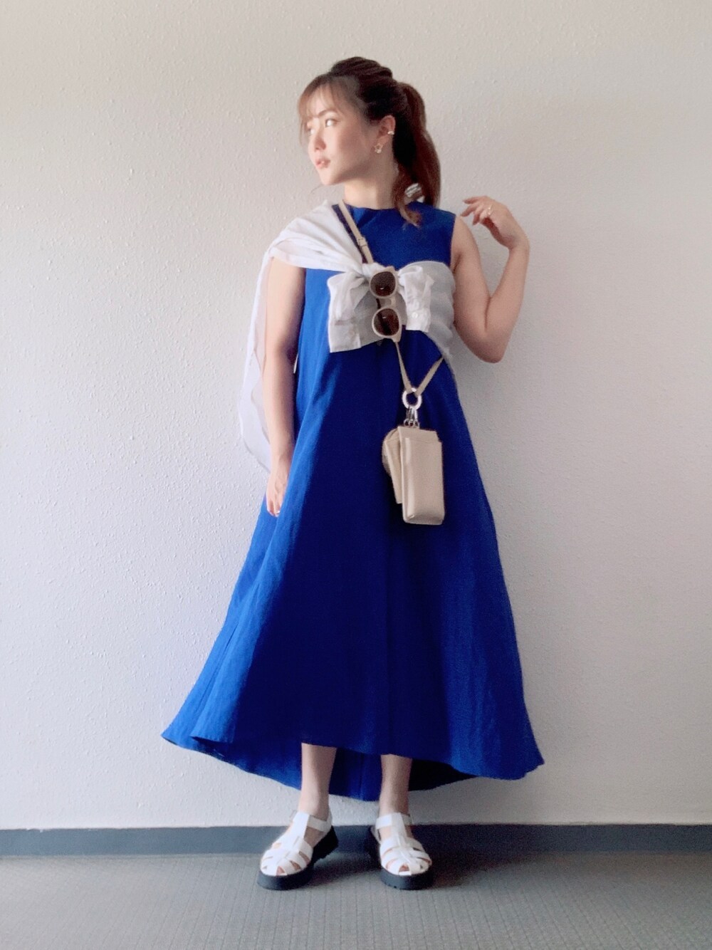 ブルー系のワンピース、ホワイト系のショルダーバッグ、ホワイト系のサンダルを着用したレディースの夏コーディネートの1枚目の写真
