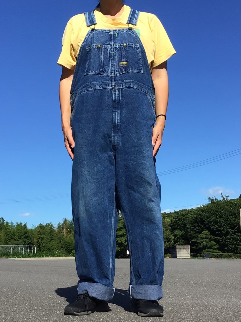 イエロー系のTシャツ/カットソー、ブルー系のサロペット/オーバーオールを着用したメンズの夏コーディネートの1枚目の写真