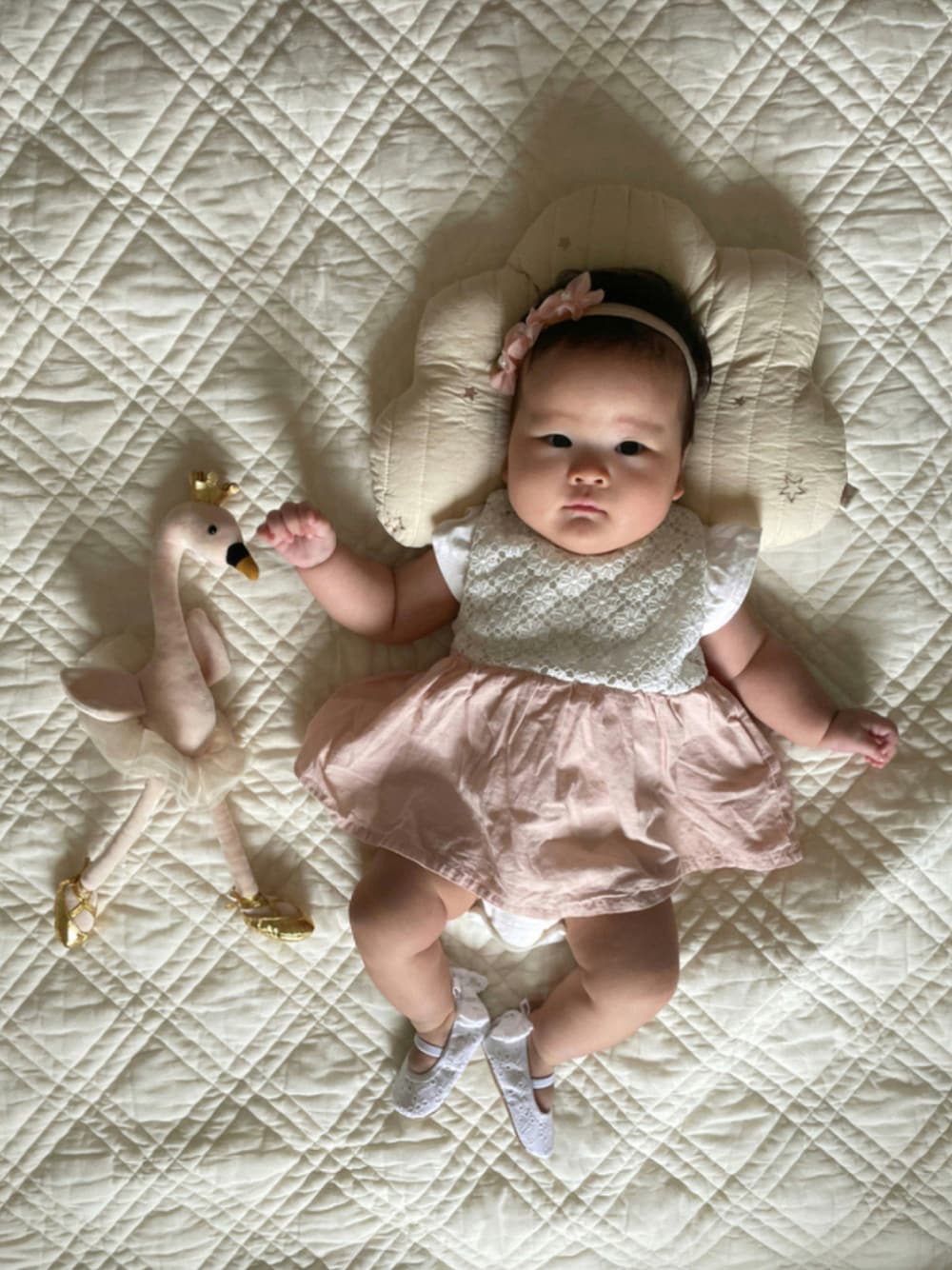 ホワイト系のバレエシューズ、ピンク系のロンパース、ホワイト系のその他ベビー用品を着用したキッズの秋コーディネートの1枚目の写真