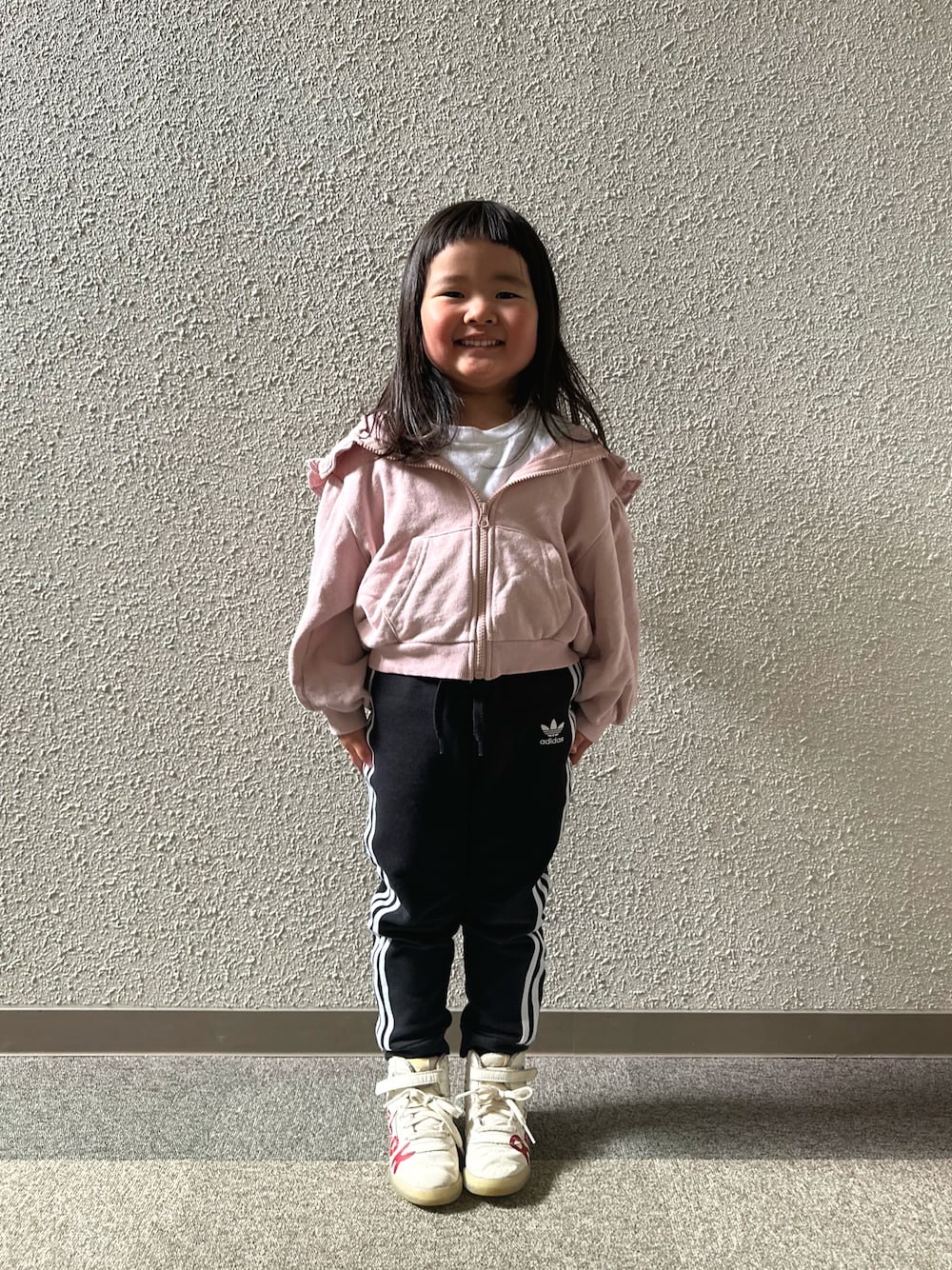 ピンク系のパーカー、ブラック系のジャージ、レッド系のスニーカーを着用したキッズの夏コーディネートの1枚目の写真