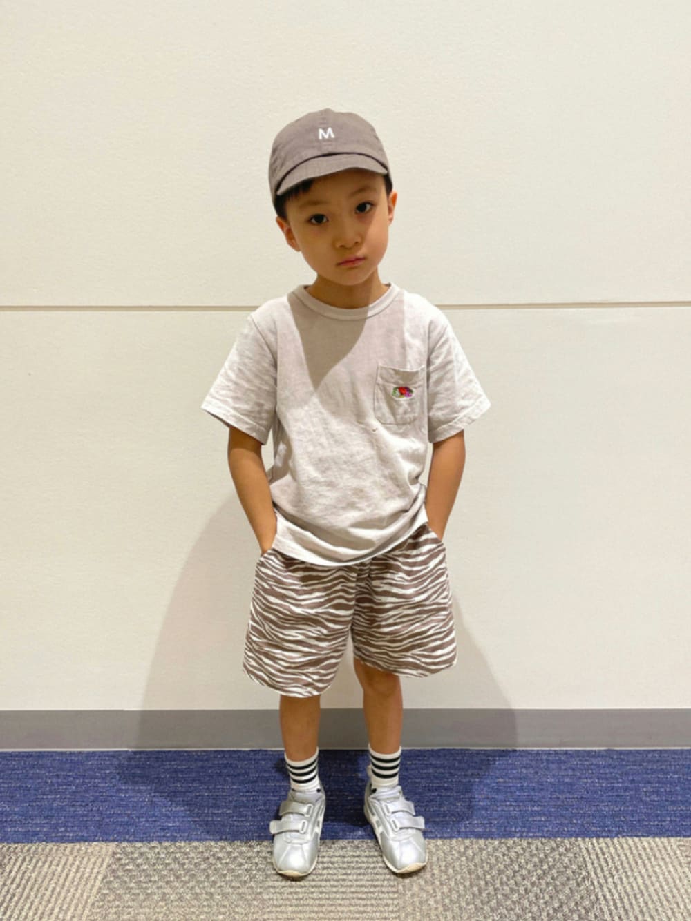 ベージュ系のTシャツ/カットソー、ベージュ系のその他パンツ、シルバー系のスニーカーを着用したキッズの秋コーディネートの1枚目の写真