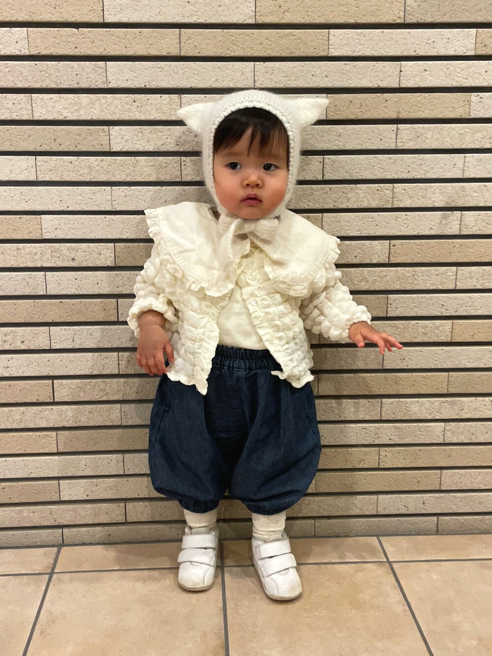 ホワイト系のTシャツ/カットソー、ホワイト系のカーディガン/ボレロ、ブルー系のデニムパンツを着用したキッズの冬コーディネートの1枚目の写真