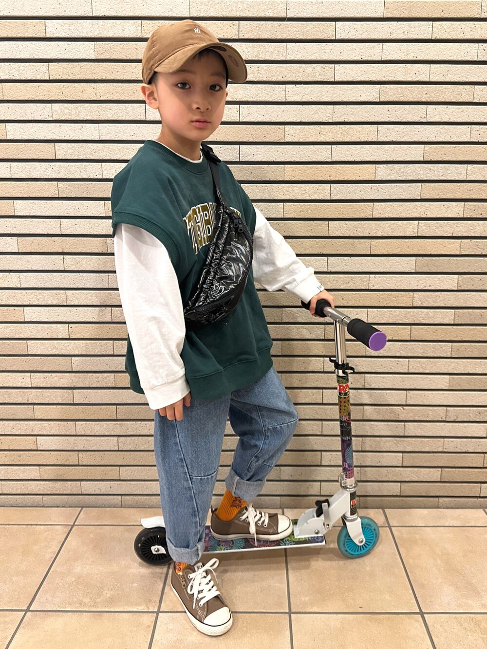 グリーン系のベスト、ホワイト系のTシャツ/カットソー、ブルー系のデニムパンツを着用したキッズの春コーディネートの1枚目の写真