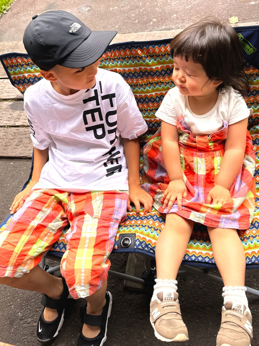 オレンジ系のワンピース/ドレス、ホワイト系のTシャツ/カットソー、オレンジ系のパンツを着用したキッズの秋コーディネートの1枚目の写真