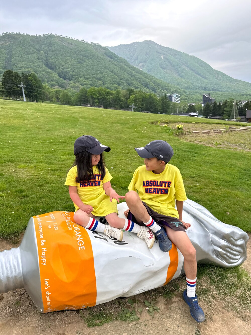 イエロー系のTシャツ/カットソー、イエロー系のワンピース、ブラウン系のパンツを着用したキッズの夏コーディネートの1枚目の写真