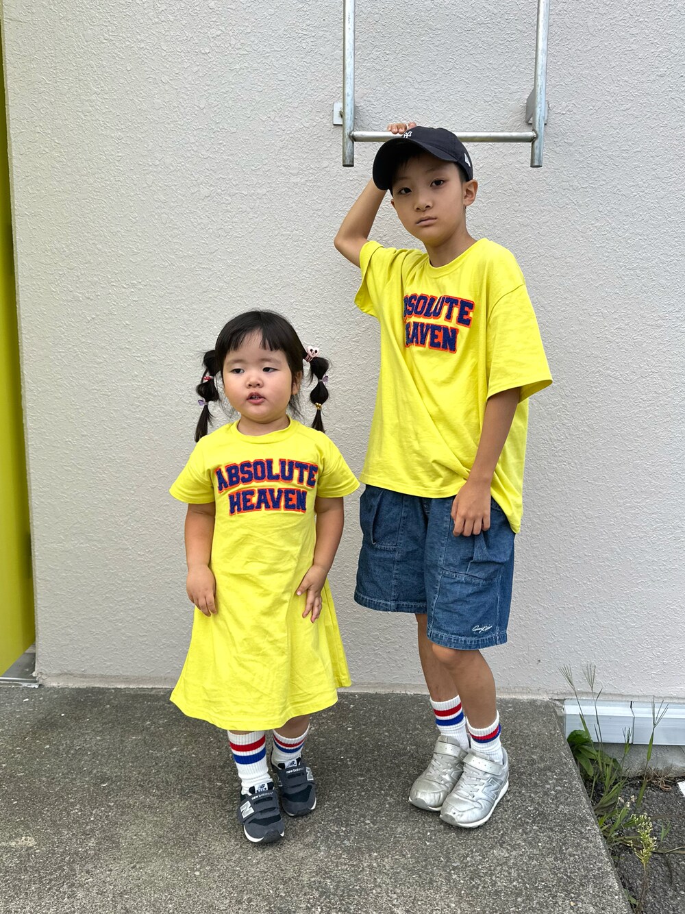 イエロー系のTシャツ/カットソー、ブルー系のデニムパンツ、シルバー系のスニーカーを着用したキッズの秋コーディネートの1枚目の写真