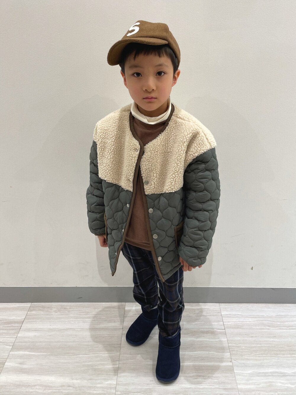 グリーン系のダウンジャケット/コート、ホワイト系のトップス、ブラウン系のアンサンブルを着用したキッズの冬コーディネートの1枚目の写真