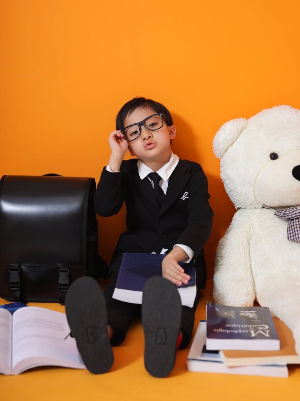 ブラック系のテーラードジャケット、ホワイト系のシャツ/ブラウス、ブラック系のその他パンツを着用したキッズの冬コーディネートの1枚目の写真