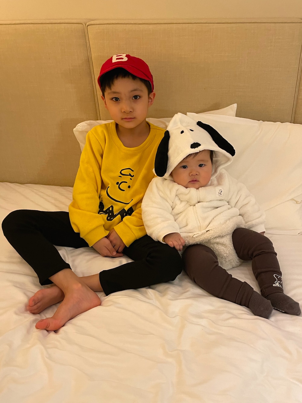 イエロー系のスウェット、ブラック系のその他パンツ、ホワイト系のパーカーを着用したキッズの秋コーディネートの1枚目の写真