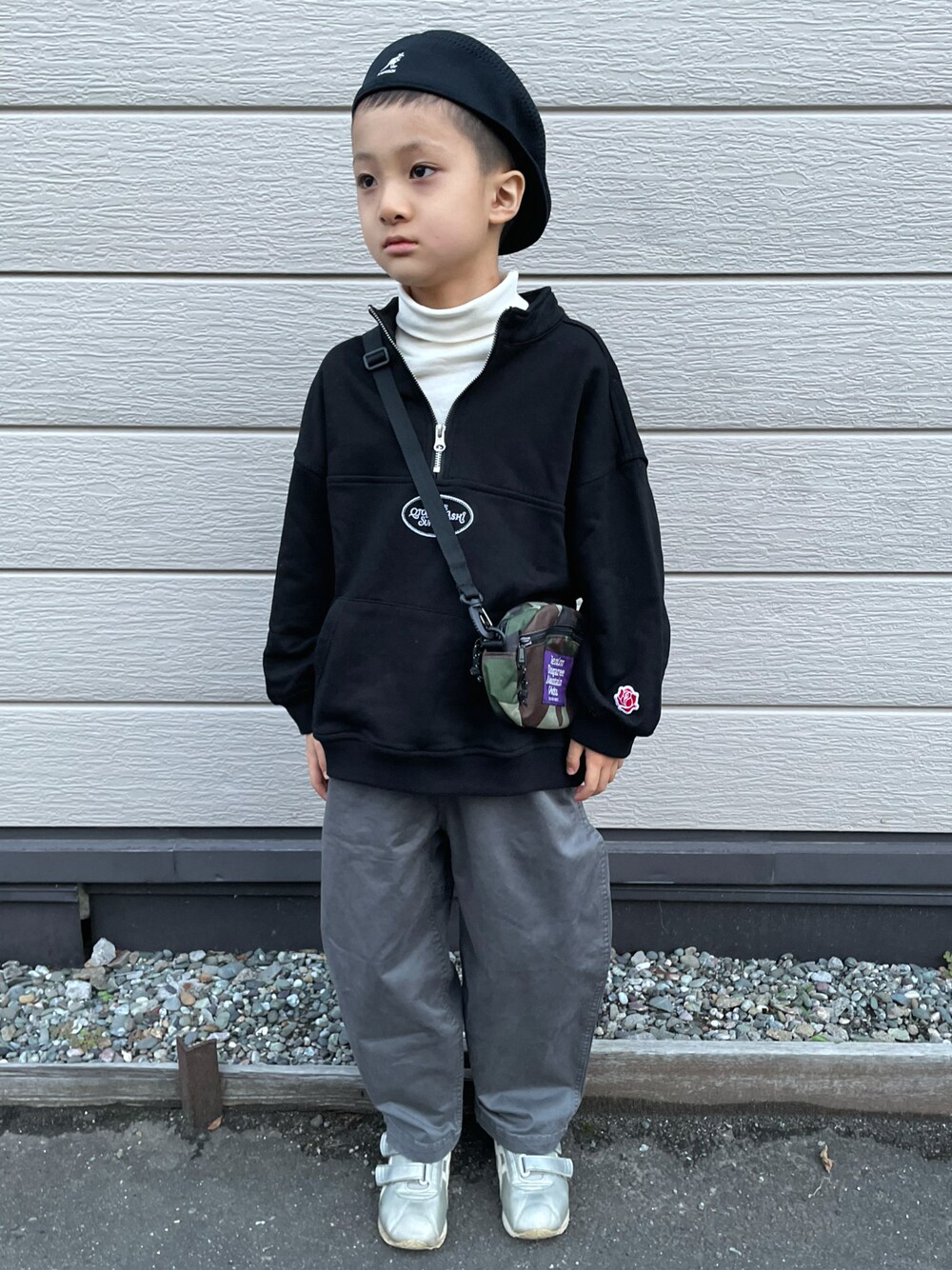 ブラック系のスウェット、ホワイト系のトップス、グレー系のチノパンツを着用したキッズの秋コーディネートの1枚目の写真