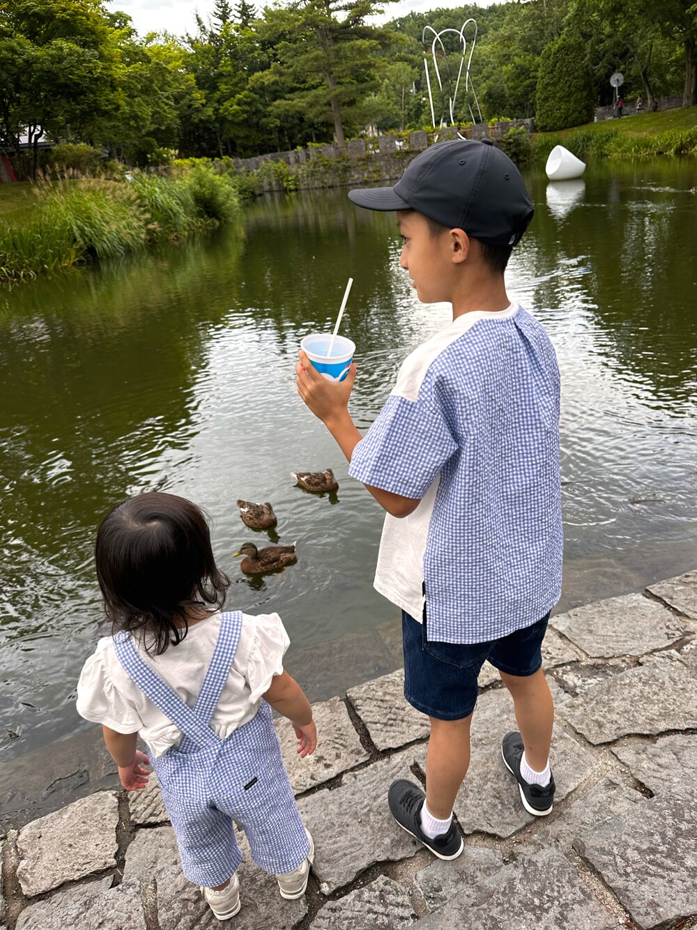 ブルー系のTシャツ/カットソー、ブルー系のデニムパンツ、ブラック系のスニーカーを着用したキッズの夏コーディネートの1枚目の写真