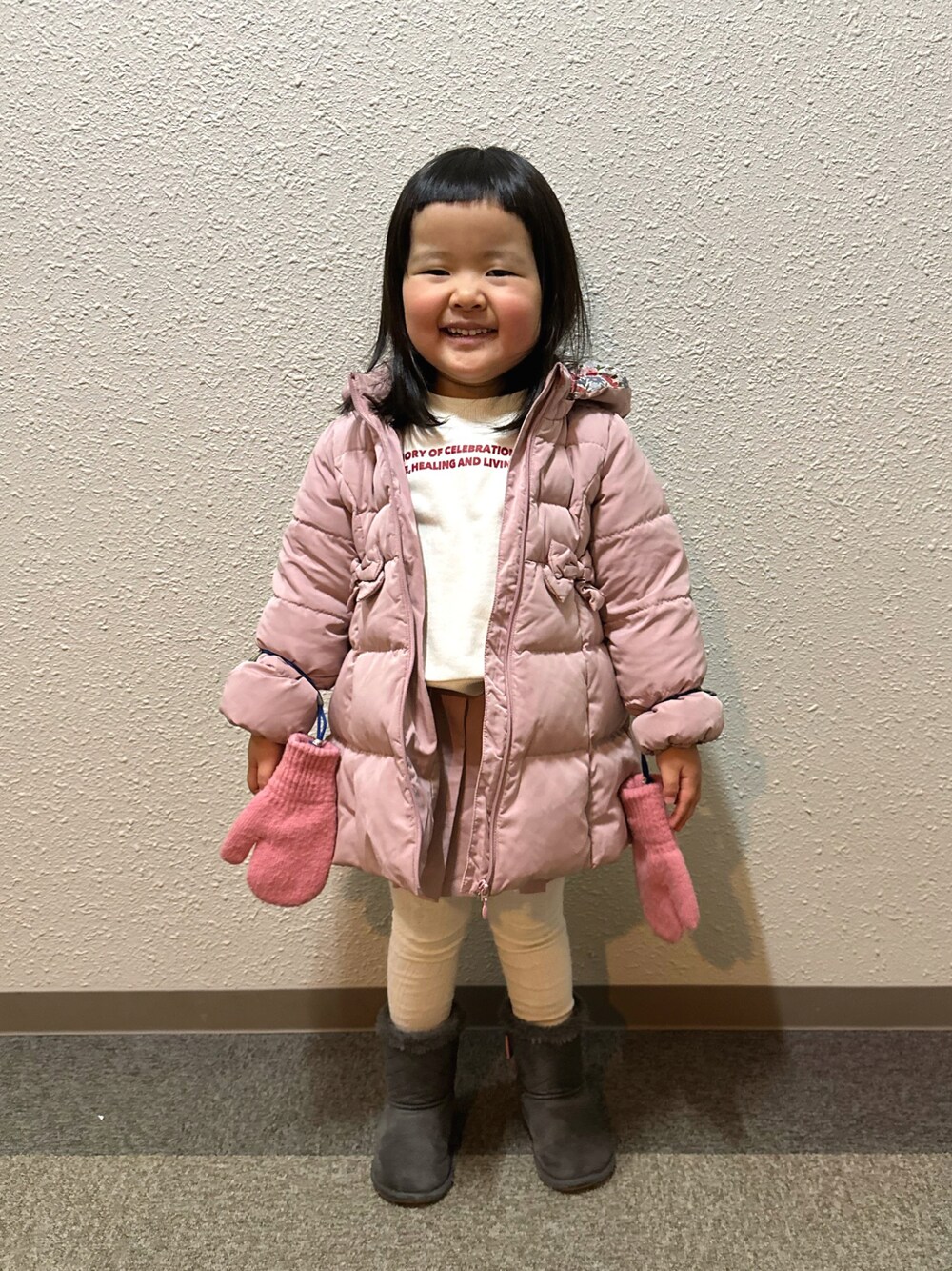ピンク系のダウンジャケット/コート、ホワイト系のスウェット、ピンク系のその他パンツを着用したキッズの冬コーディネートの1枚目の写真