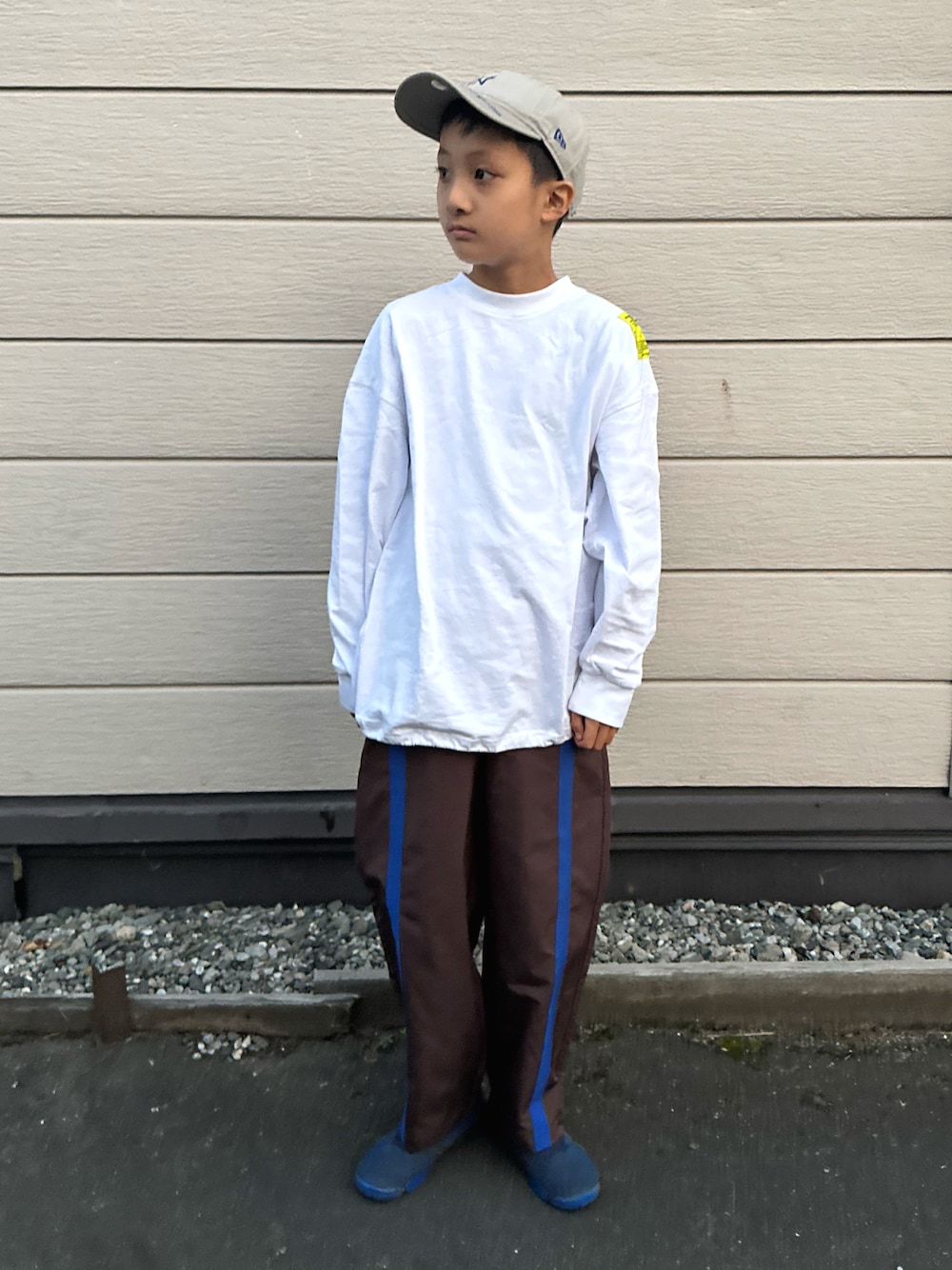 ブルー系のスニーカー、ホワイト系のTシャツ/カットソー、ブラウン系のパンツを着用したキッズの秋コーディネートの1枚目の写真
