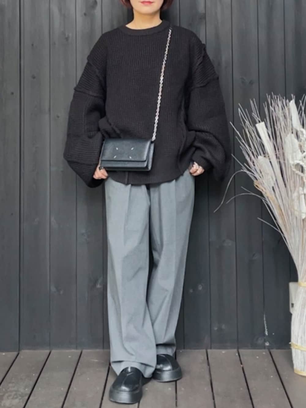 ブラック系のニット/セーター、グレー系のパンツ、ブラック系のブーツを着用したレディースの秋コーディネートの1枚目の写真
