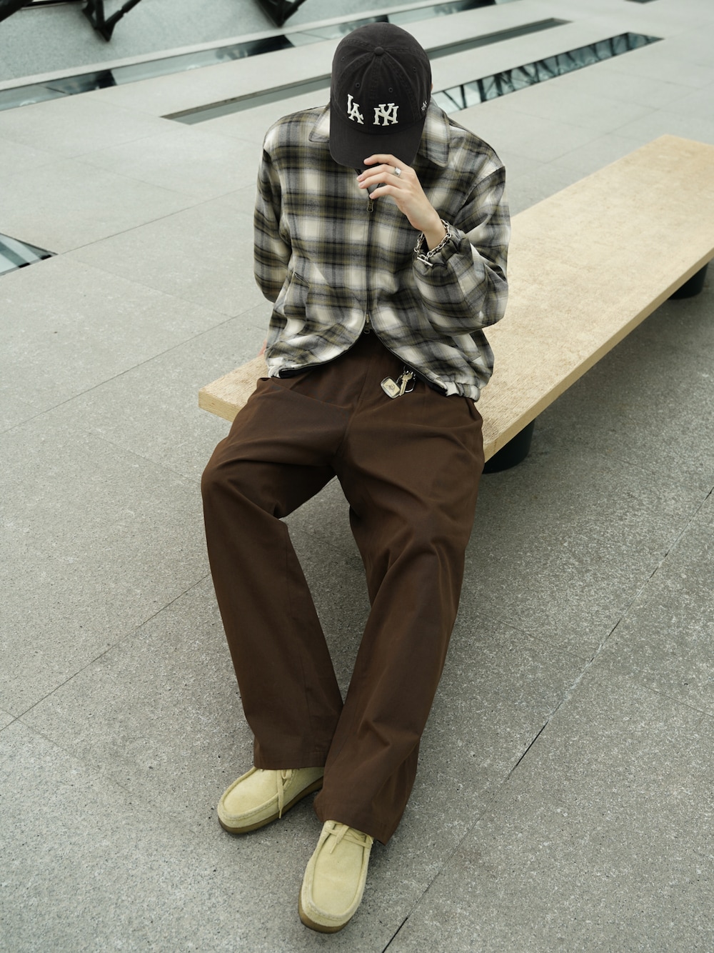 ブラウン系のデニムパンツ、ベージュ系のブーツ、ブラック系のブルゾンを着用したメンズの冬コーディネートの1枚目の写真