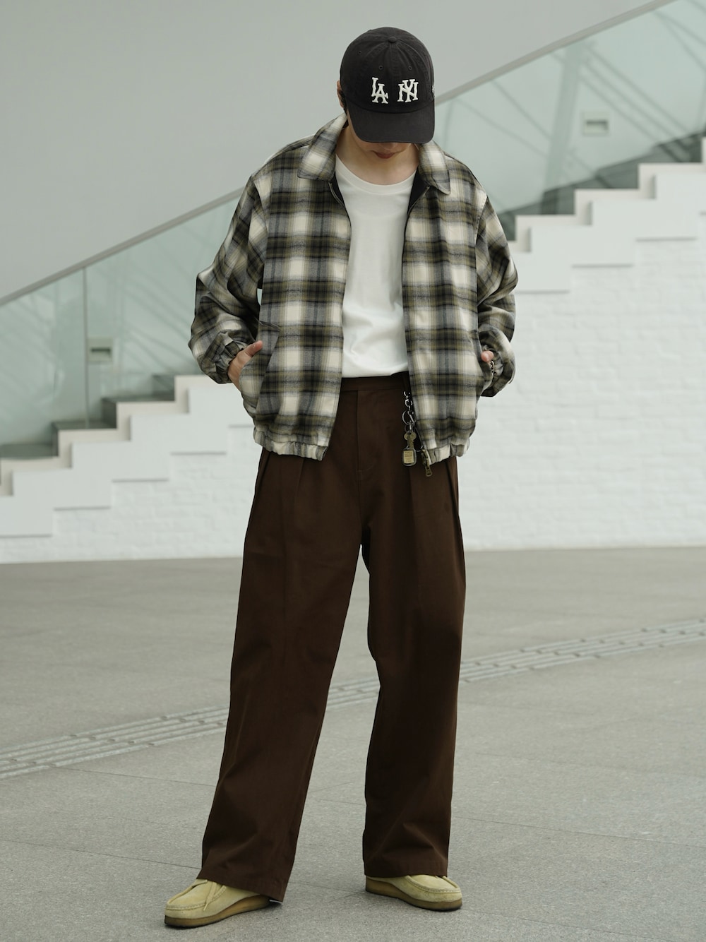 ブラック系のブルゾン、ブラウン系のデニムパンツ、ベージュ系のブーツを着用したメンズの春コーディネートの1枚目の写真