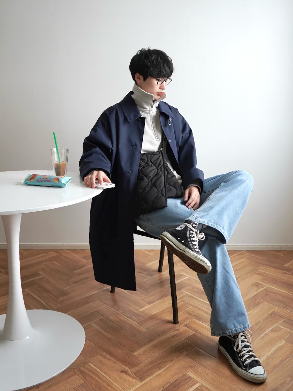 ブルー系のデニムパンツ、グレー系のスウェット、ブルー系のステンカラーコートを着用したメンズの春コーディネートの1枚目の写真