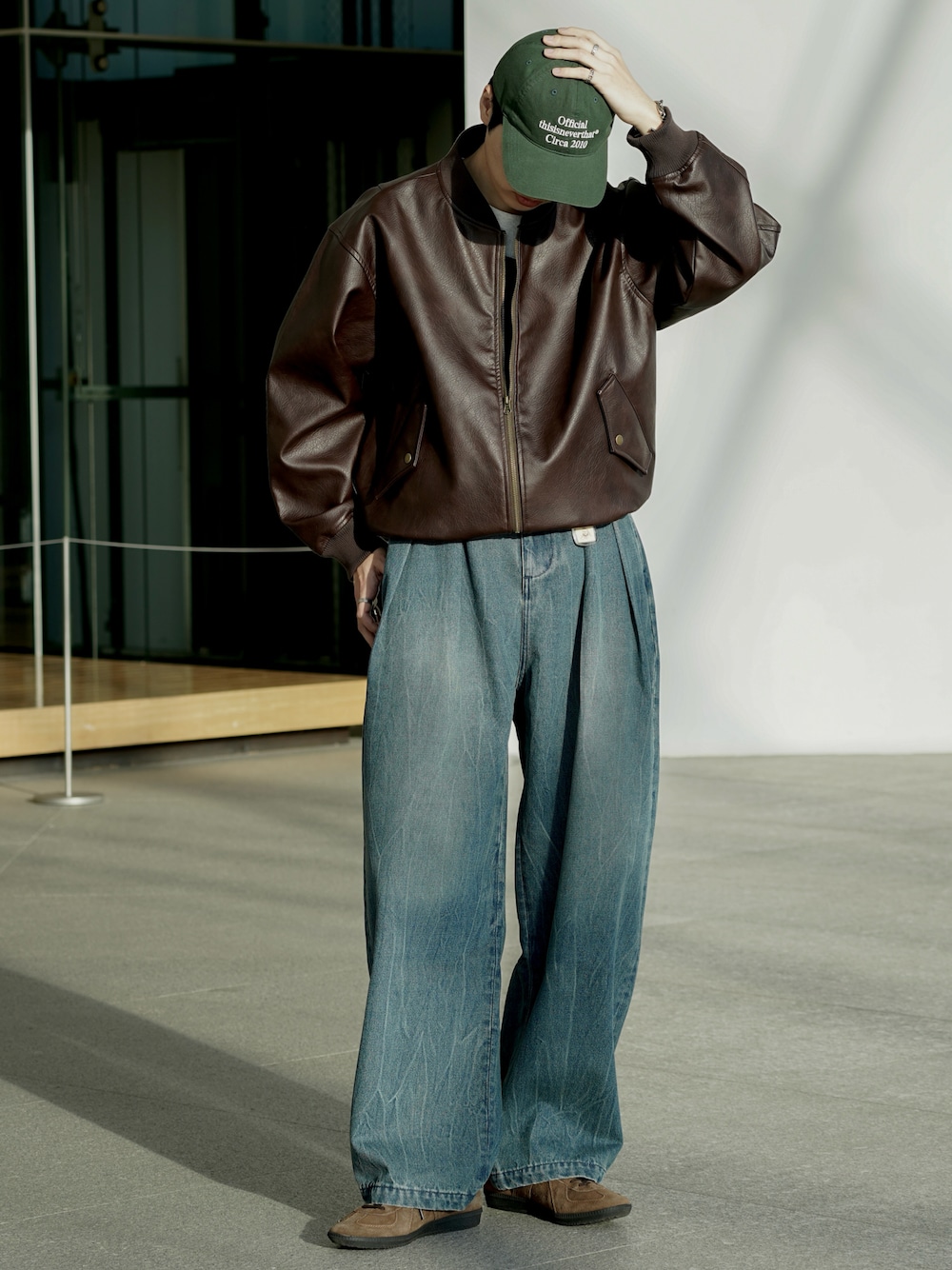 ブラウン系のMA-1、ブラウン系のスニーカー、ブルー系のデニムパンツを着用したメンズの冬コーディネートの1枚目の写真