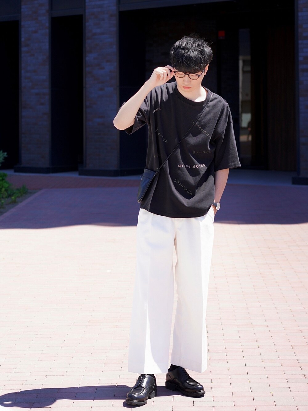 ブラック系のTシャツ/カットソー、ホワイト系のデニムパンツ、ブラック系のショルダーバッグを着用したメンズの夏コーディネートの1枚目の写真