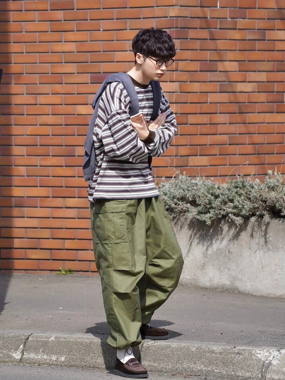 ブラウン系のTシャツ/カットソー、グリーン系のカーゴパンツ、ホワイト系のその他を着用したメンズの春コーディネートの1枚目の写真