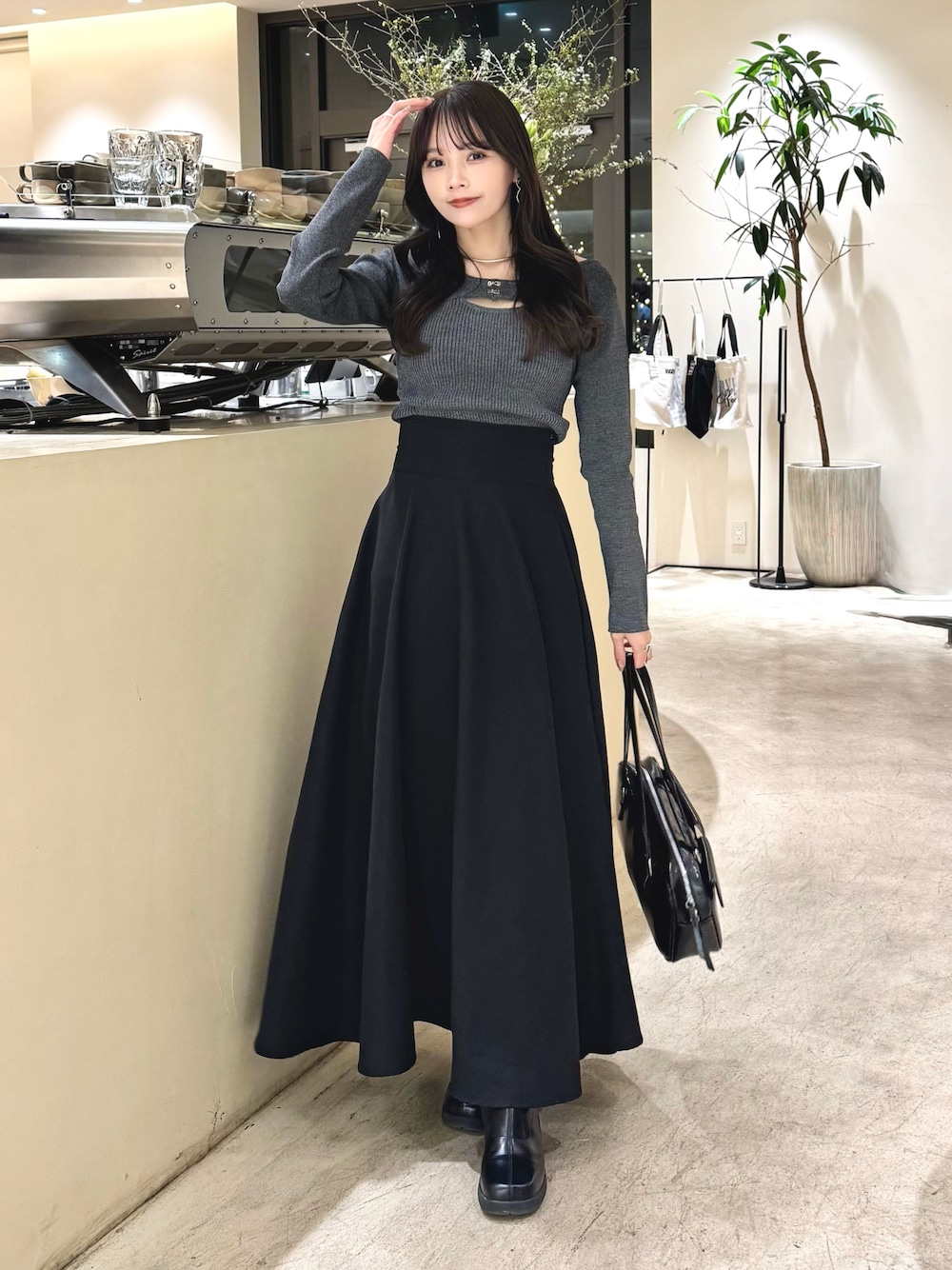その他のニット/セーター、ブラック系のスカート、ブラック系のブーツを着用したレディースの冬コーディネートの1枚目の写真