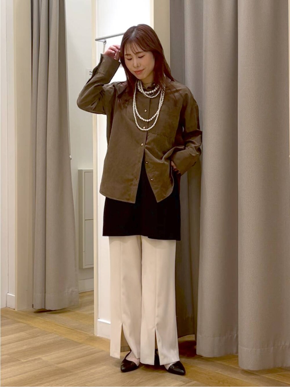 ブラウン系のシャツ/ブラウス、ホワイト系のスラックス、ブラック系のスカートを着用したレディースの秋コーディネートの1枚目の写真