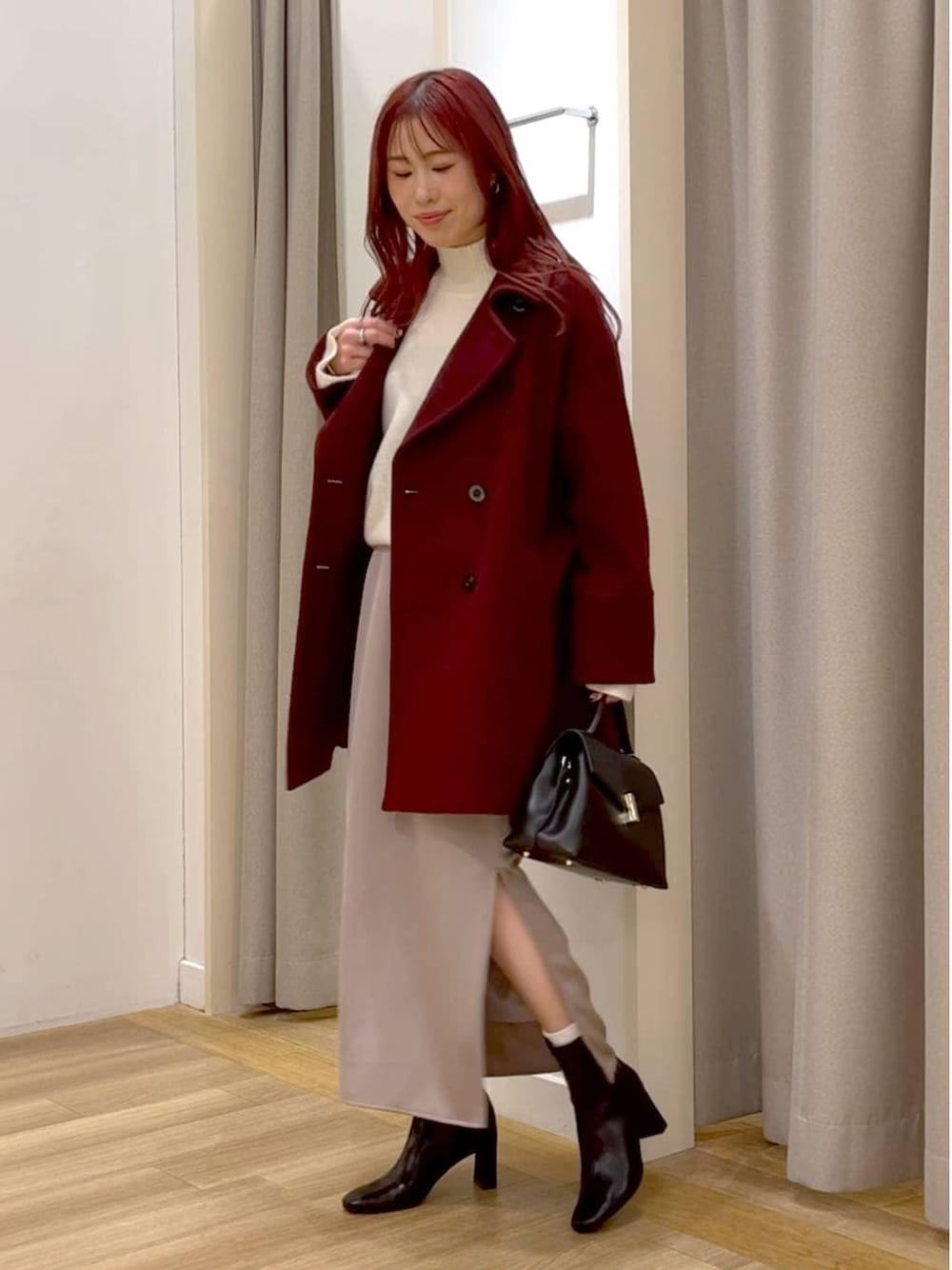 ホワイト系のニット/セーター、レッド系のピーコート、ブラック系のブーツを着用したレディースの冬コーディネートの1枚目の写真