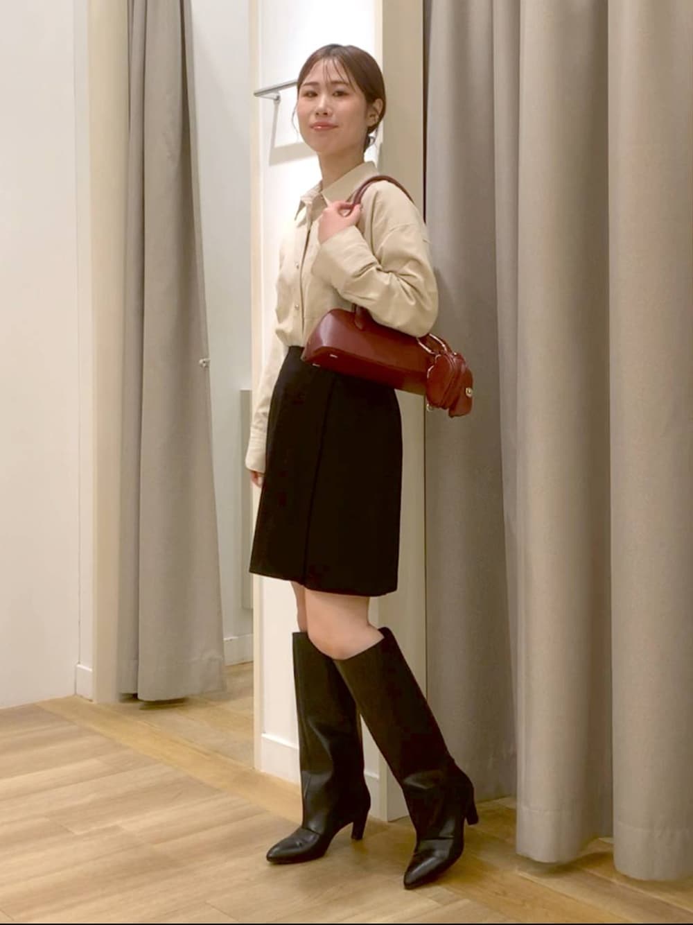 レッド系のボストンバッグ、レッド系のショルダーバッグ、ブラック系のスカートを着用したレディースの秋コーディネートの1枚目の写真